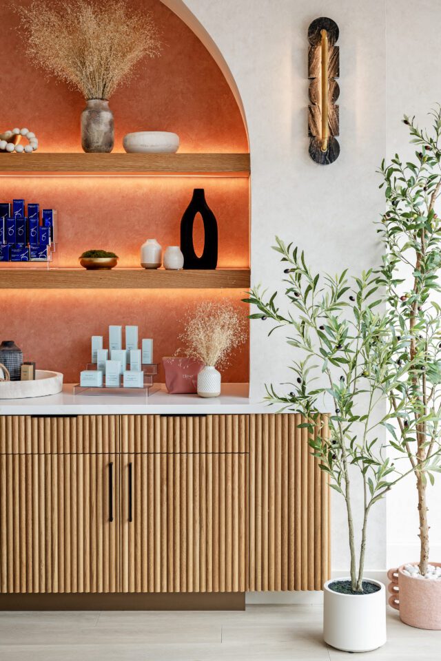 Elase Sarasota med spa retail display with ZO Skin Health products, warm-lit wooden shelves, and arched terracotta niche