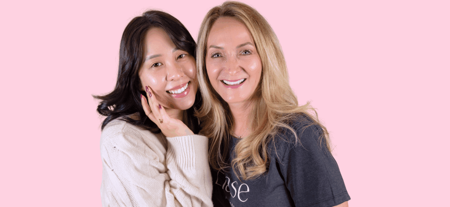 Pink background with two women smiling