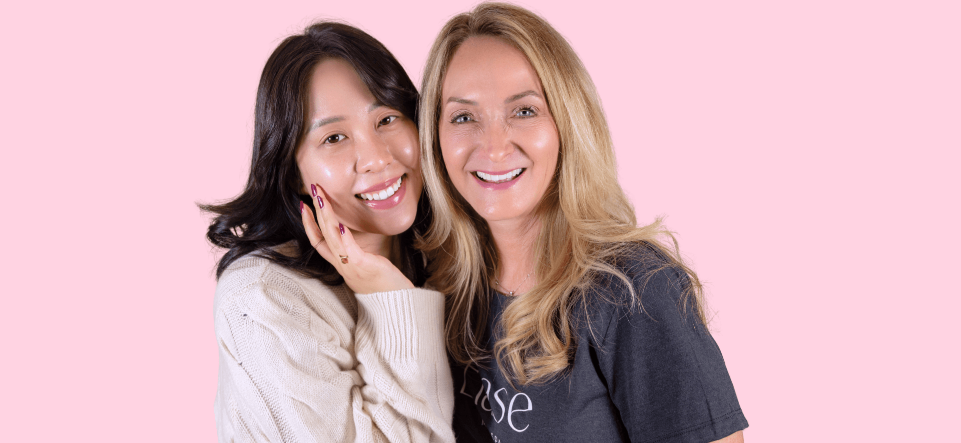 Pink background with two women smiling